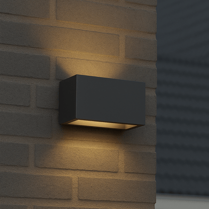 Een moderne, zwarte wandlamp met warm wit licht, bevestigd aan een bakstenen muur. Perfect voor buitenverlichting en moderne tuin- of terrasdecoratie.
