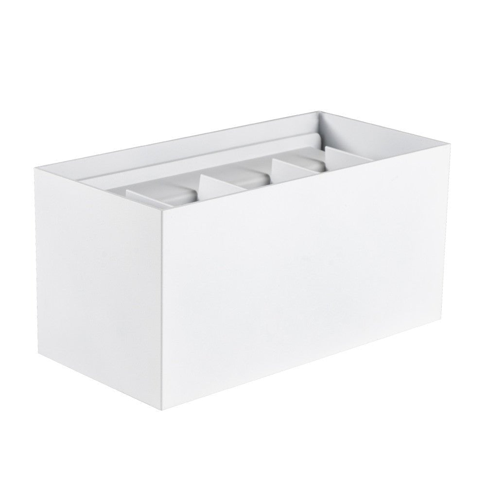 Een witte, rechthoekige wandlamp met een moderne, minimalistische vorm, bevestigd aan een grijze bakstenen muur en werkt als buitenverlichting voor een warme, uitnodigende sfeer.