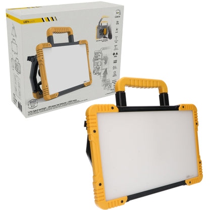 Een robuust, geel en zwart werklicht met handvat, omringd door diverse batterijen van merken zoals Makita, DeWalt, Bosch en Metabo, geschikt voor professioneel gebruik in de bouw of reparatie.