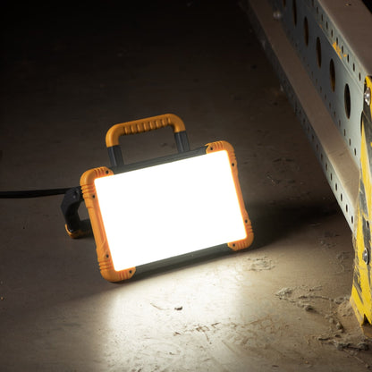 Een robuuste, gele en zwarte LED werklamp met handvat en kabel, geschikt voor professioneel gebruik in workshops of op bouwplaatsen.