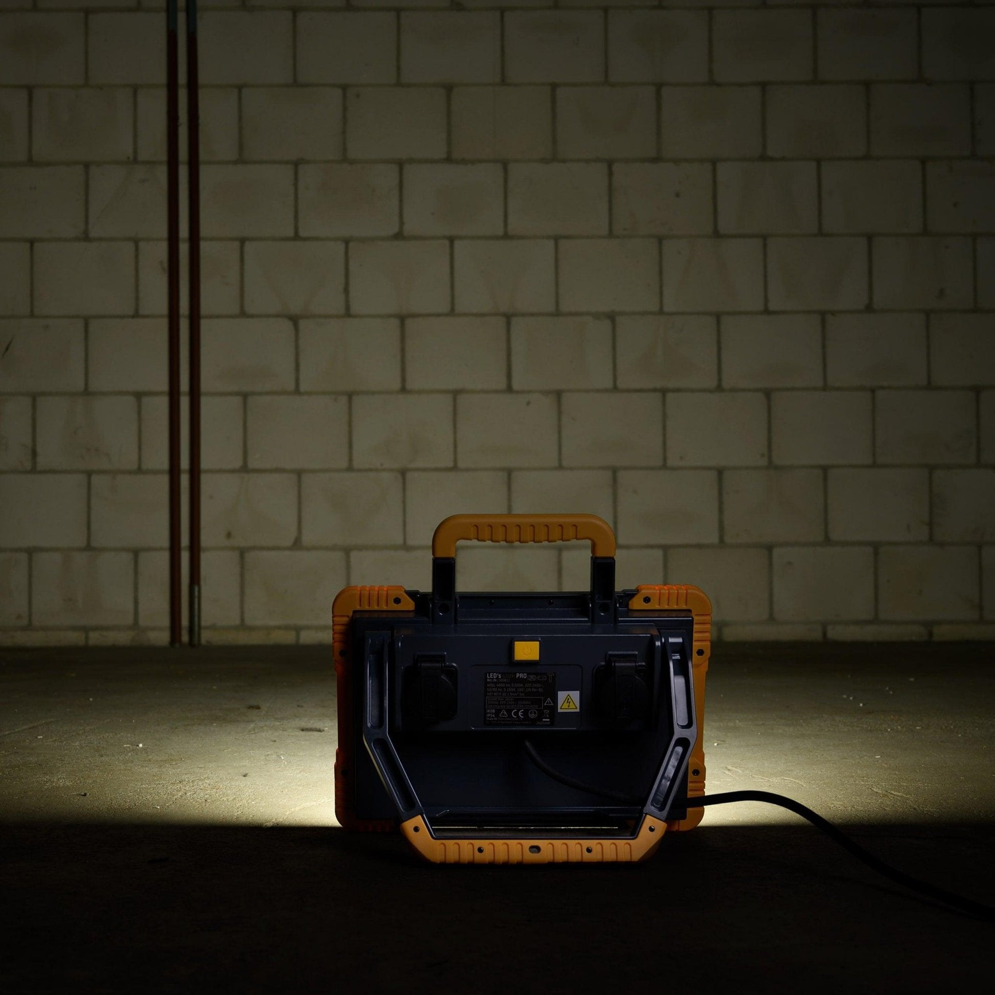 LED’s work PRO professionele werklicht met robuust geel-zwart frame, witte verlichtingsvlak en opgerolde kabel, geschikt voor bouw- en reparatiewerkzaamheden.
