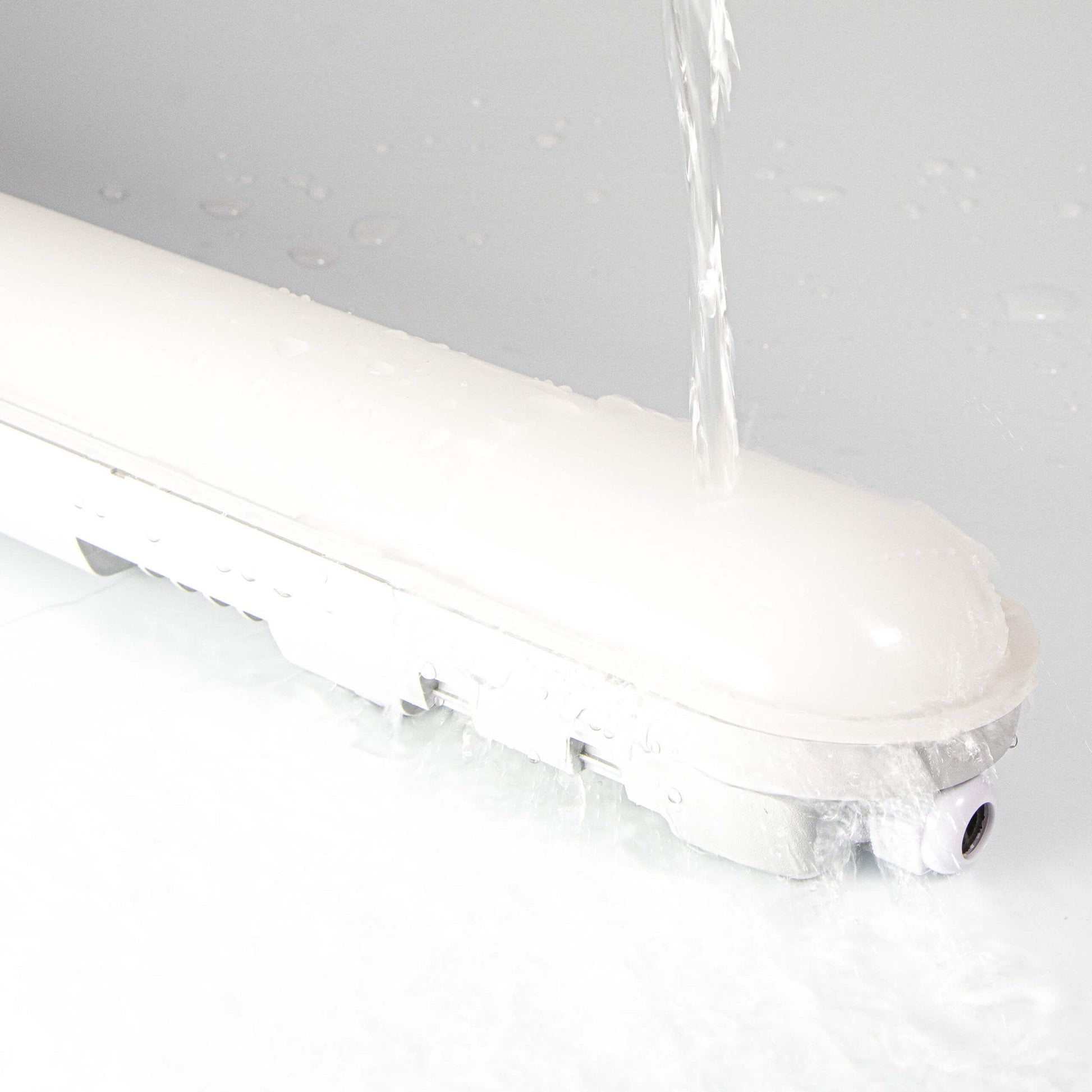 Een witte, langwerpige LED-verlichting met een glanzende kap en een textuurrijke behuizing, geschikt voor industriële of commerciële ruimtes. Zichtbaar D-keurmerk in de hoek.