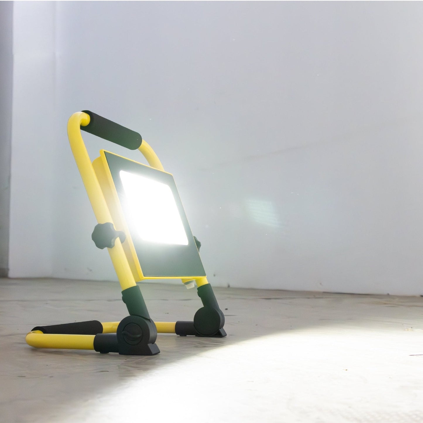 Geel opvouwbare LED werklamp met zwart handvat en verstelbare poten, geschikt voor bouw- en tuinwerk. Zichtbare USB-oplaadpoort en 1400 lumen verlichting.
