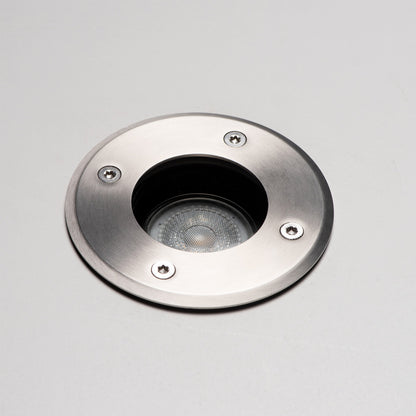 Zilverkleurige, ronde bodemlamp met glazen kap en zichtbare schroeven, voorzien van een zwarte cilindrische basis. Geschikt voor tuinverlichting en buitenverlichting.