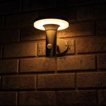 Zachte, warme LED-verlichting met bewegingssensor, geïnstalleerd op een textuurrijke bakstenen muur. Modern, zilverkleurig ontwerp voor veilige buitenverlichting en nachtverlichting.