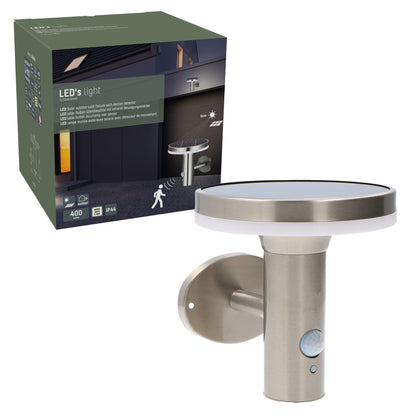 Zachte, warme LED-verlichting met bewegingssensor, geïnstalleerd op een textuurrijke bakstenen muur. Modern, zilverkleurig ontwerp voor buitenverlichting en veiligheid.
