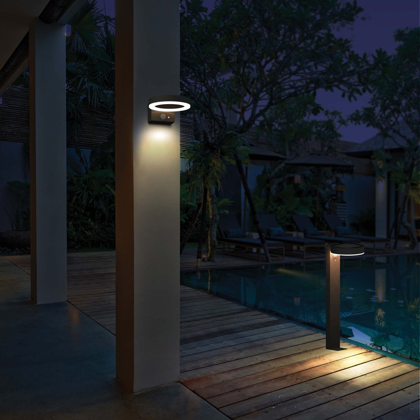 Een moderne, zwarte ringvormige wandlamp met warm wit licht, bevestigd op een textuurrijke bakstenen muur. Uitgerust met een bewegingssensor en een aan/uit-knop voor automatische verlichting in de tuin of op de veranda.