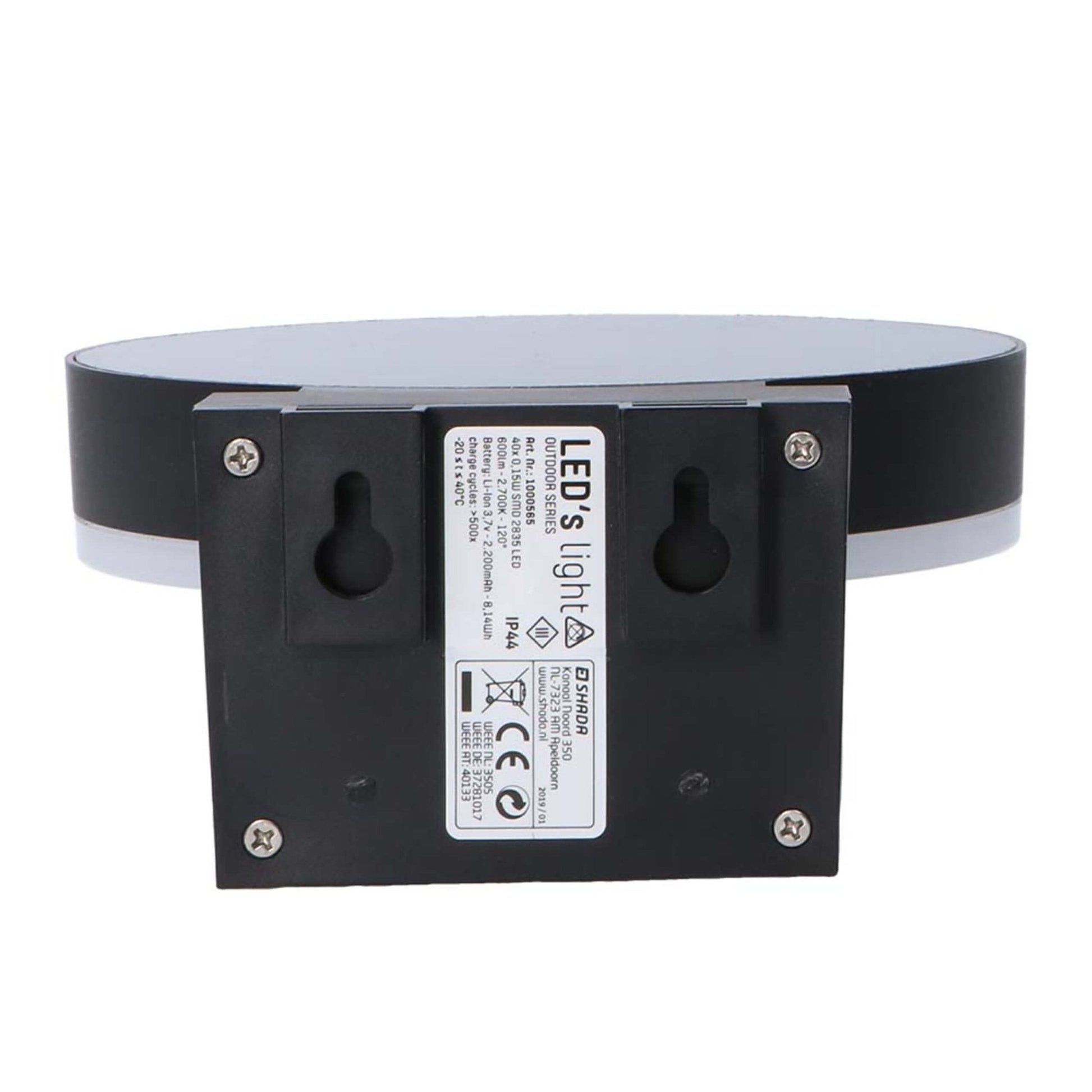 Een moderne, zwarte ringvormige wandlamp met warm wit licht, gemonteerd op een textuurrijke bakstenen muur. Uitgerust met bewegingssensor en aan/uit knop voor automatische verlichting in de entree of gang.