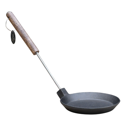 Zwarte kookpan met houten handvat en metalen steel, voorzien van een hanglabel. Geschikt voor koken op kampvuur of grill, met een robuust, anti-afsluitend oppervlak.