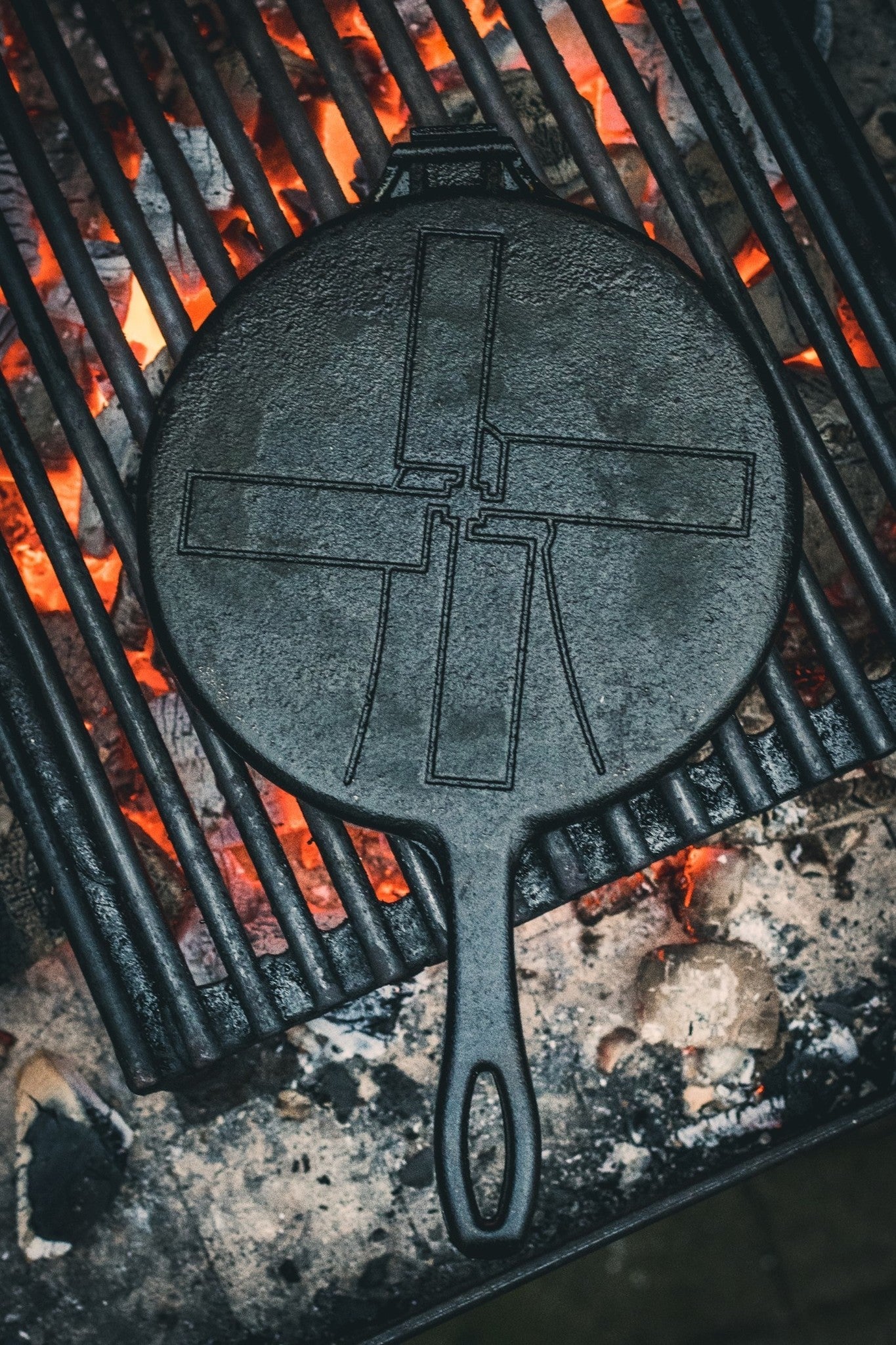 Zwarte, ronde wafelpan met opengeslagen deksel en duidelijke rasterpatronen, geschikt voor het bakken van wafels. Gemaakt van kookstalen, ideaal voor wafelbakken en grillen.