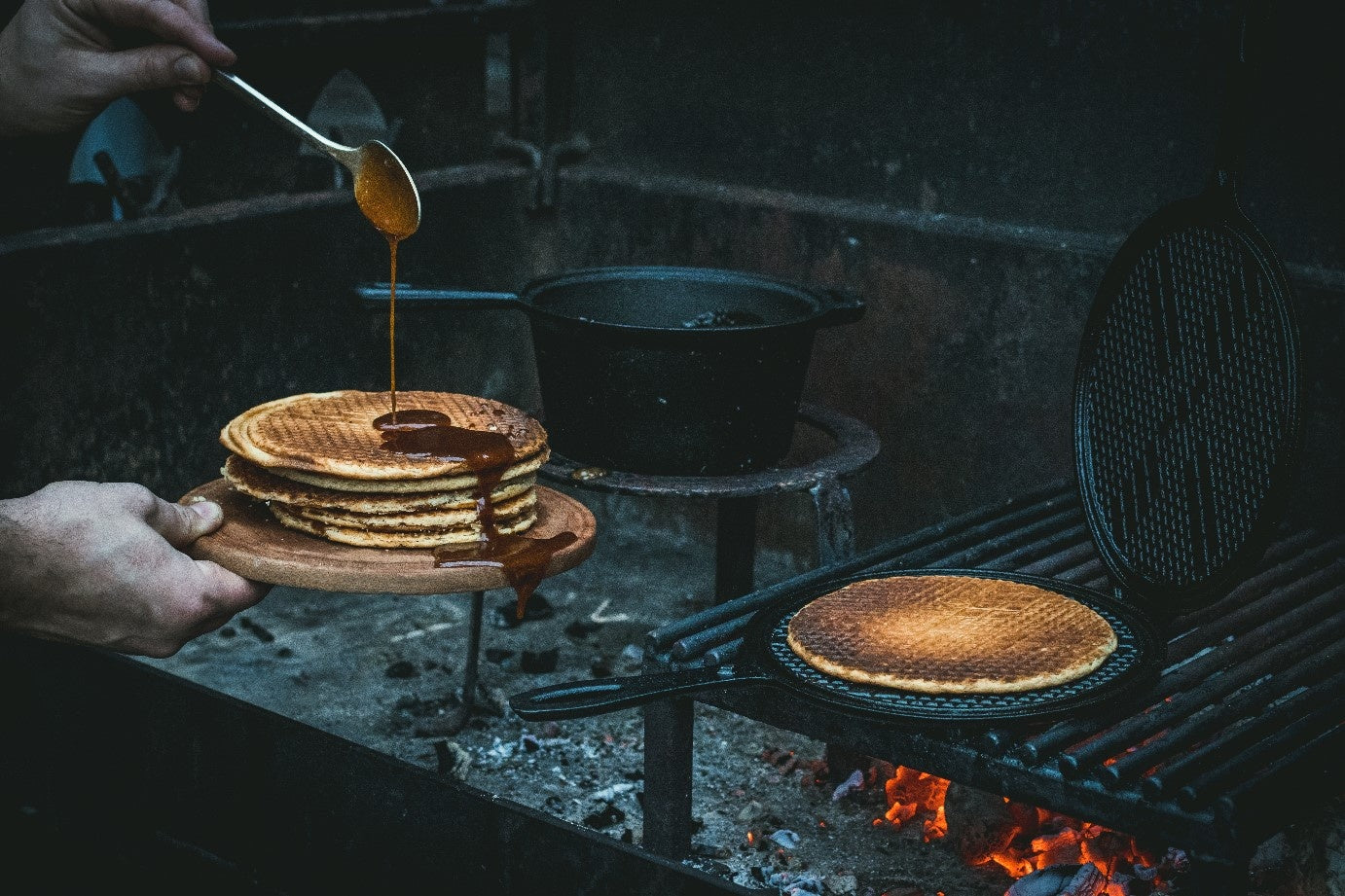 Zwarte, ronde wafelpan met opengeslagen deksel en gestructureerde grillvlakken voor perfecte wafels. Gemaakt van koolstofstaal, geschikt voor wafelbakken en grillen.