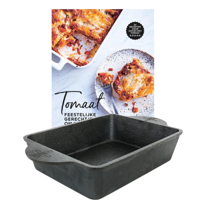 Zware, zwarte kookpan met handvatten, geschikt voor het bakken van tomatenrecepten. Achtergrond toont een receptboek en een geroosterde tomatenlasagne.