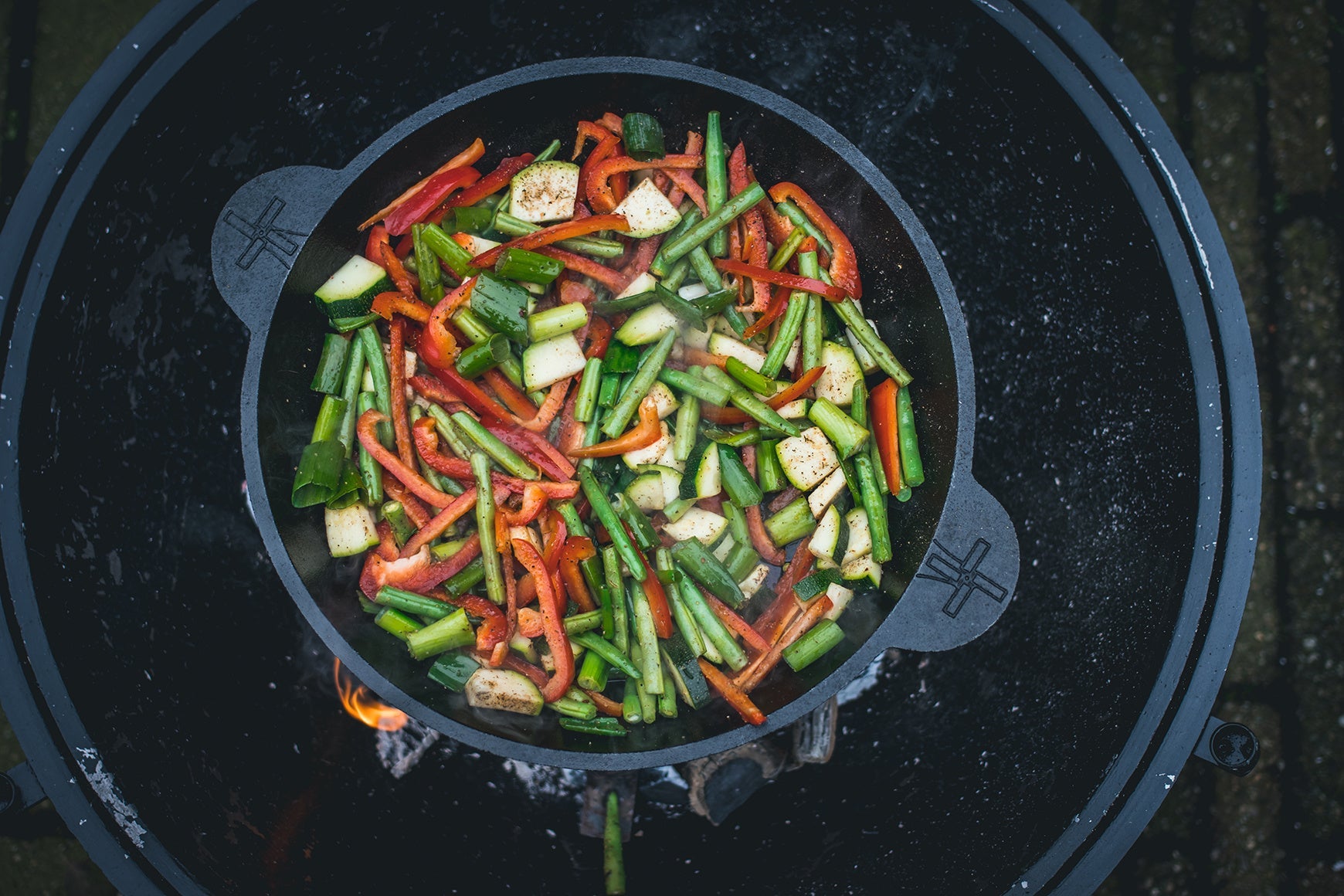 Zware, zwarte kookpan van gietijzer met twee handvatten, geschikt voor grillen en bakken. Perfect voor professionele en thuiskeuken gebruik.