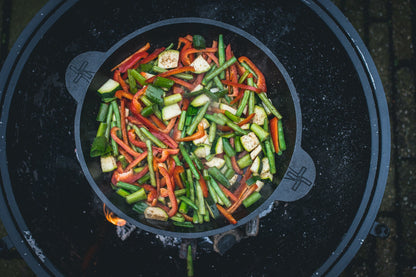 Zware, zwarte kookpan van gietijzer met twee handvatten, geschikt voor grillen en bakken. Perfect voor professionele en thuiskeuken gebruik.