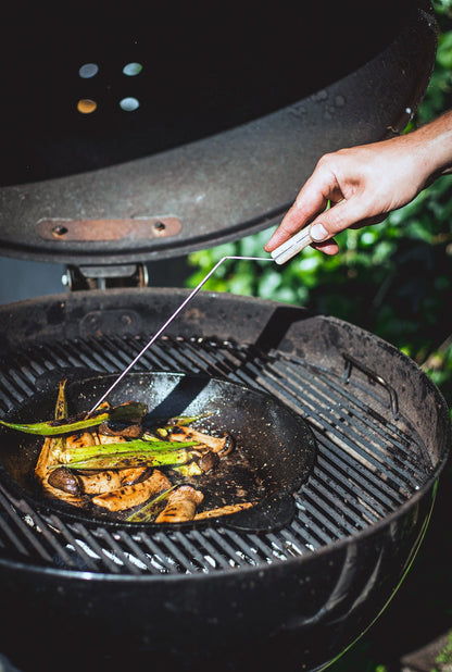 Zware, zwarte gietijzeren koekenpan met twee handvatten, geschikt voor grillen en bakken. Perfect voor professionele en thuiskeuken gebruik.