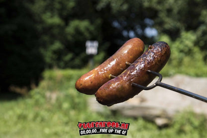 Een zwart, metalen barbecue spies met een dubbele vork aan één kant en een handige haak aan de andere, geschikt voor het grillen van vlees of groenten op de open haard of barbecue.