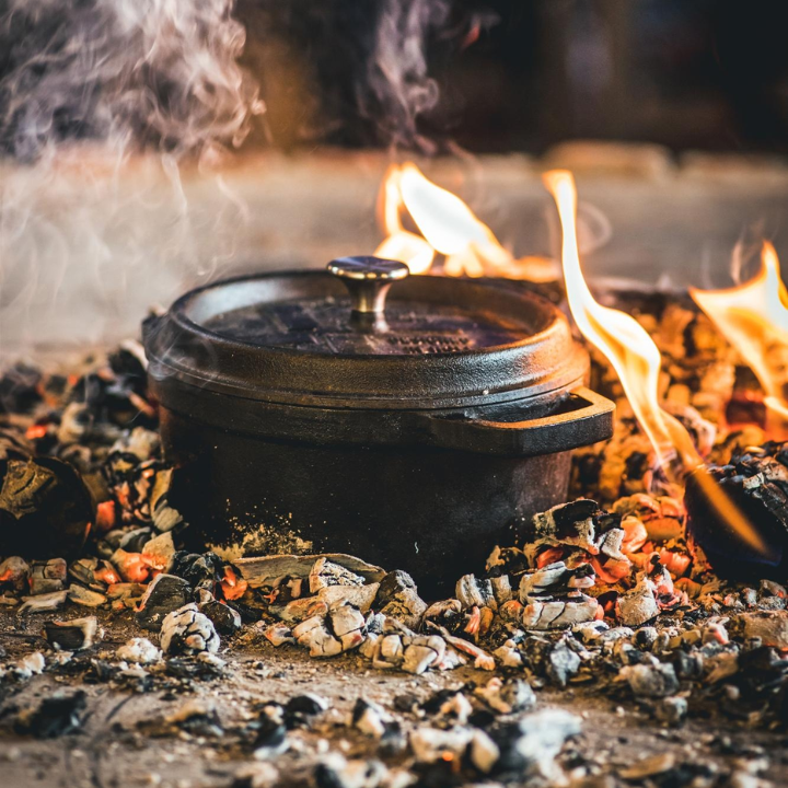 Zwarte kastijnpot met afdekking, gemaakt van zwaar gietijzer, voorzien van handvatten en een gedetailleerd deksel met ‘Designed in Holland’. Ideaal voor langzame kookmethodes en traditionele gerechten.