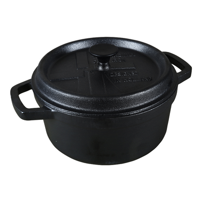 Zwarte kookpan van gietijzer met afdekking, voorzien van handvatten en het merklogo. Geschikt voor langzame kookmethodes en traditionele kooktechnieken.
