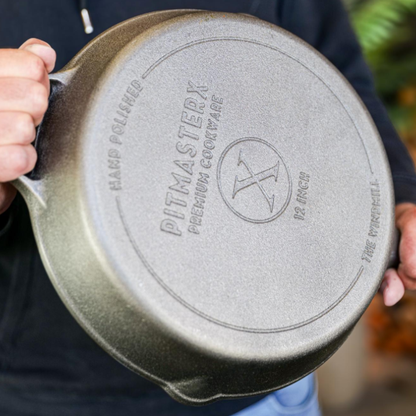 Zilverkleurige kookpan met gladde binnenkant en twee handvatten, geschikt voor grillen en bakken. Gietijzeren pan met robuust ontwerp voor professionele kookresultaten.