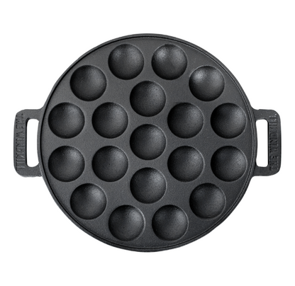 Zwarte, ronde cast iron pannetje met twaalf bolvormige gaten, voor het bakken van traditionele Japanse takoyaki. Met handvatten aan weerszijden, geschikt voor gebruik op de kookplaat of grill.