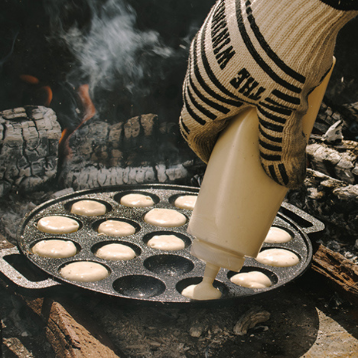 Zwarte, ronde cast-iron pannen met twaalf bolvormige gaten, voor het bakken van traditionele Japanse takoyaki. Met handvatten voor gemakkelijk hanteren en hoge hittebestendigheid.