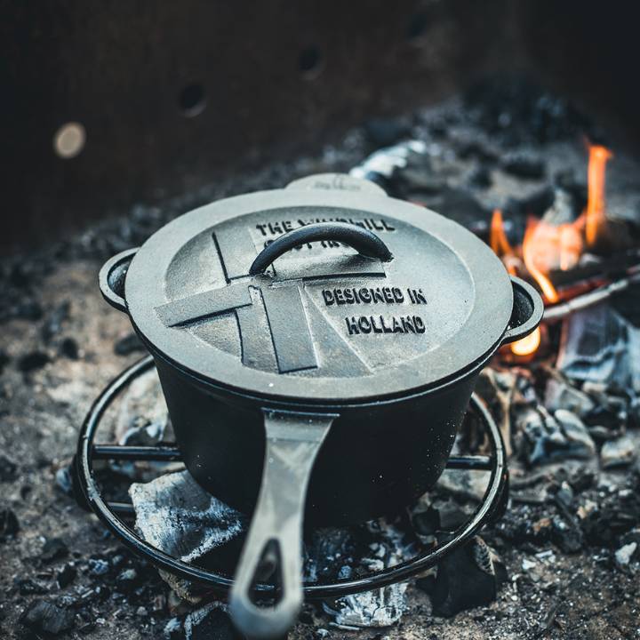 Zwarte kookpan van gietijzer met afsluitende deksel en handvat, geschikt voor koken en bakken. Gietijzeren kookpan voor professioneel koken en grillen.
