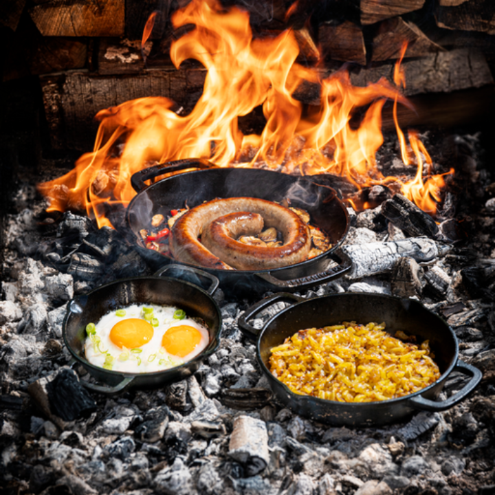 Zware, zwarte kookpan van gietijzer met twee handvatten, geschikt voor grillen en bakken. Perfect voor professionele en thuiskeuken gebruik.