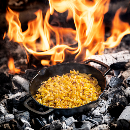 Zware, zwarte gietijzeren koekenpan met twee handvatten, geschikt voor grillen en bakken. Perfect voor professionele en thuiskeuken gebruik.
