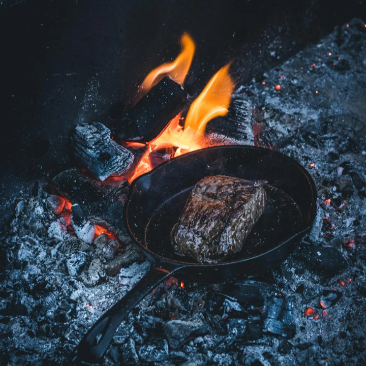 Zwarte kookpan van gietijzer met gladde bodem en lang handvat, geschikt voor grillen en bakken. Robuust ontwerp voor elke keuken, perfect voor professioneel koken en dagelijkse maaltijden.
