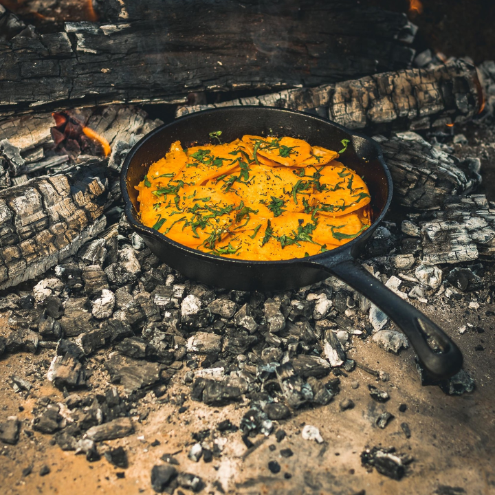 Zwarte kookpan van gietijzer met gladde binnenkant en lang handvat, geschikt voor grillen en bakken. Robuust ontwerp voor elke keuken, perfect voor professionele en thuiskeukens.