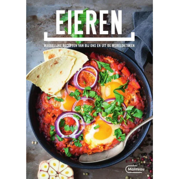 Zwarte kookpan met gladde bodem en handvat, naast een kookboek over eieren. Geschikt voor het koken van eieren in de oven of op het vuur.