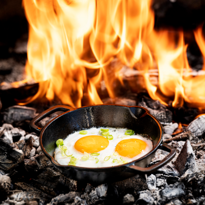 Zware, zwarte gietijzeren koekenpan met twee handvatten, geschikt voor grillen en bakken. Perfect voor professionele en thuiskeuken gebruik.