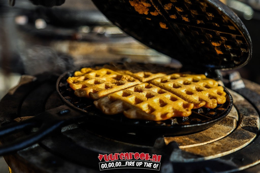 Zwart, ronde kookpan met handvat en kruispatroon, geschikt voor kampvuur. Gemaakt van koolstofstaal, ideaal voor outdoor koken en reizen.