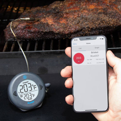 Zwart ronde BlueDOT thermometer met digitale display, toont huidige temperatuur 76°F en alarm 165°F. Bluetooth-icoon en bedieningsknoppen zichtbaar voor gebruik bij kookapparatuur.