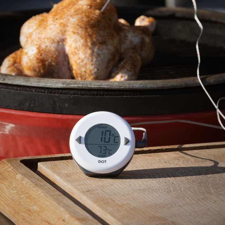 Een witte, ronde digitale temperatuurmeter met zwarte knoppen en een helder scherm dat 34°C huidige temperatuur en 75°C alarm toont. Ideaal voor keuken- en badkamercontrole.