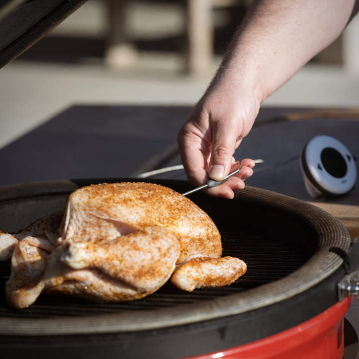Een witte, ronde digitale thermometer met zwarte knoppen en een helder scherm dat 34°C huidtemperatuur en 75°C alarm toont. Geschikt voor medische of persoonlijke temperatuurcontrole.
