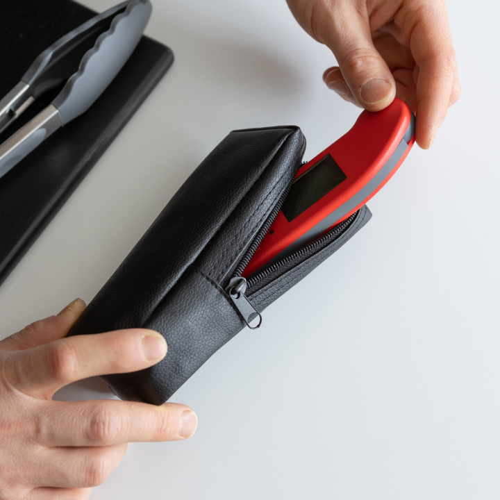 Zwart leerportemonnee met rits en textuur, geschikt voor dagelijks gebruik. Compacte tas voor portemonnee en kleine accessoires.