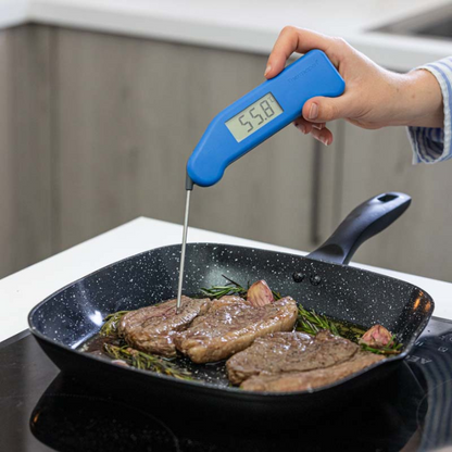 Blauwe digitale vlees thermometer met zichtbare schermweergave van 21,1°C, zilverkleurige metalen sensor en het merk Thermooen. Geschikt voor precieze temperatuurmeting bij kook- en baktoepassingen.