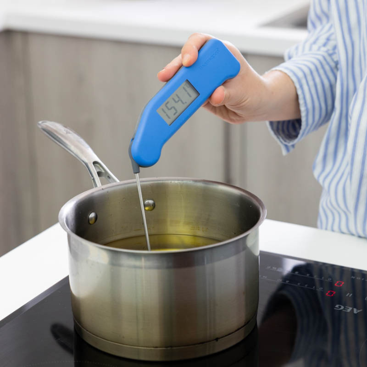 Blauwe digitale vlees thermometer met zichtbare schermweergave van 21,1°C, zilverkleurige metalen sensor en het merk Thermooen. Geschikt voor nauwkeurige temperatuurmeting bij koken en bakken.