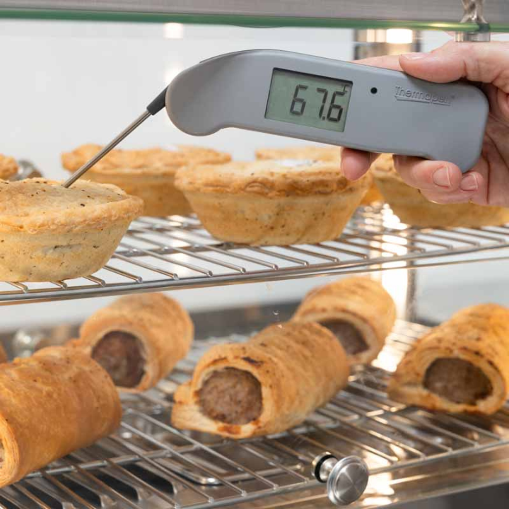 Grijze digitale Thermomaten met zichtbare temperatuur van 20,7°C, voorzien van een metalen meetstok en het merklogo. Ideaal voor kook- en barbecue-toepassingen.