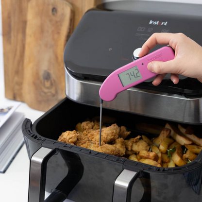Een roze digitale vlees thermometer met een scherp metalen sensor en een helder display dat 20,7°C toont, geschikt voor precieze temperatuurmeting tijdens het koken van vlees.