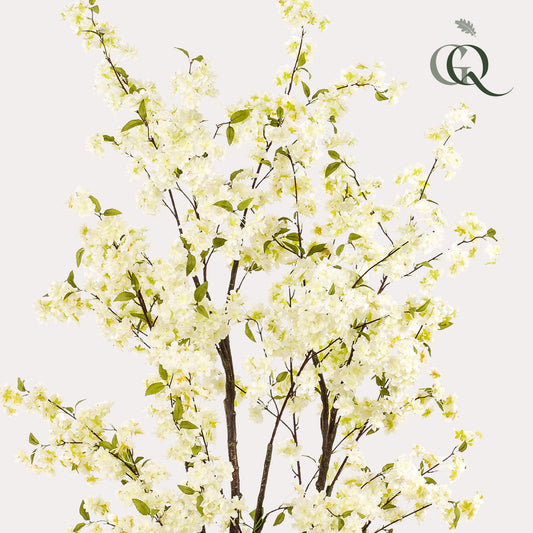 Een kunstbloemenboom met witte kersenbloesems en groene bladeren in een grijze pot, ideaal voor binnenruimtes. Perfect voor decoratie in woonkamers of als seizoensgebonden interieurversiering.