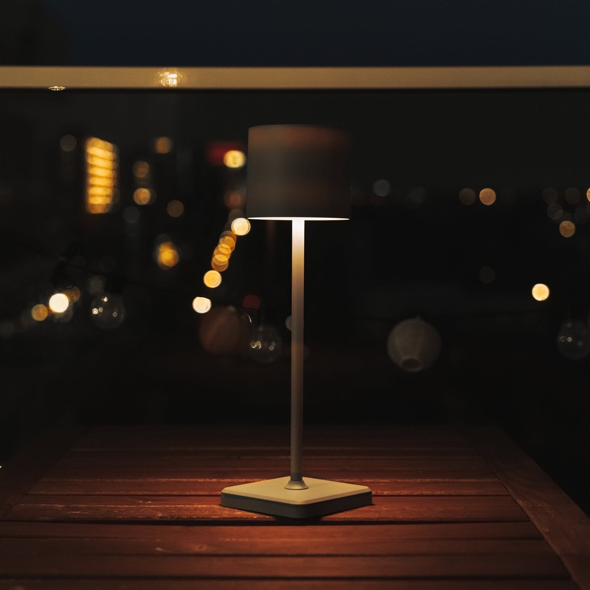 Grijze staand lamp met zwart textiel bedieningspaneel en USB-kabel, geschikt voor moderne woonkamer of slaapkamer. Zie ook de warme lichtkleur en de compacte, draadloze bediening voor comfortabele verlichting.