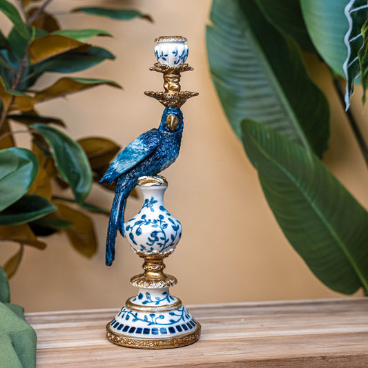 Een blauwe papegaaienfiguur op een Delftsblauw porseleinen voetstuk met goudkleurige accenten, perfect als decoratief object voor een elegante woonkamer of als unieke tafeldecoratie.