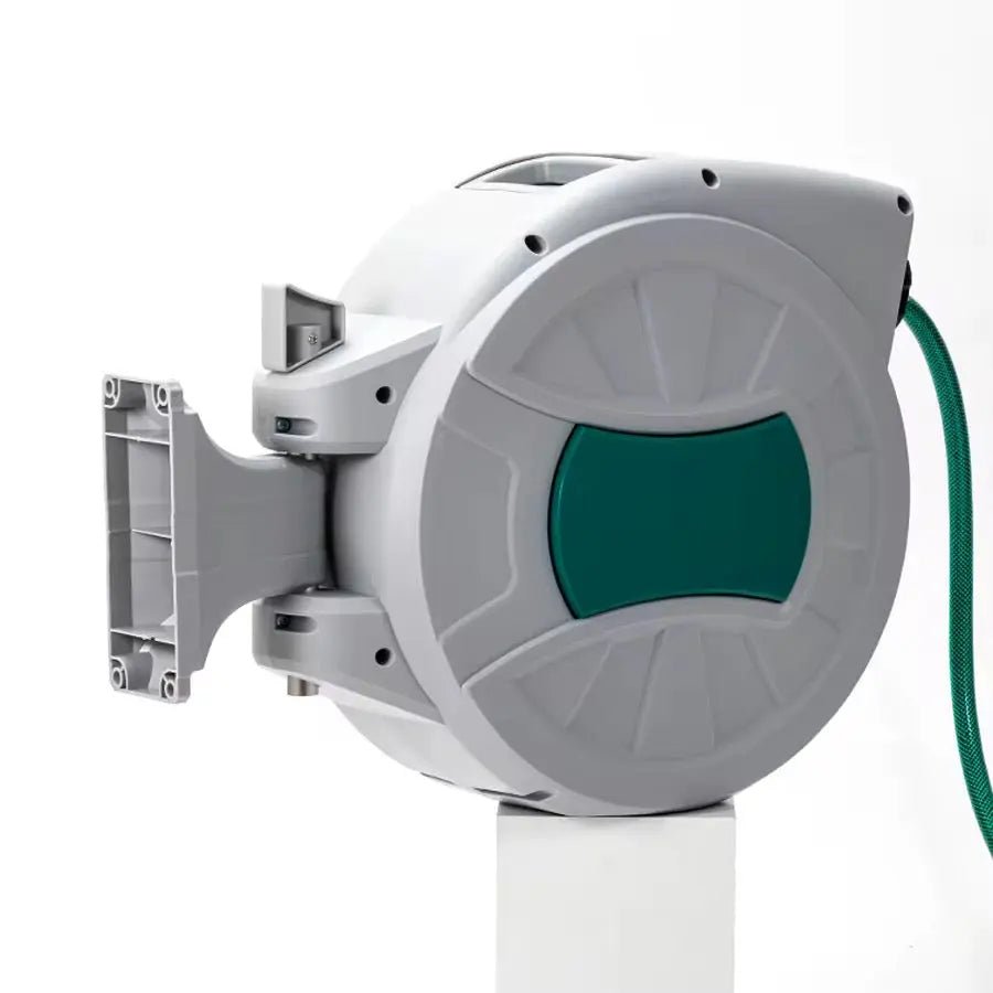 Een witte, wandmonteerde tuinslangrol met groene accenten en een flexibele slang, geschikt voor tuin- en tuinbouwtoepassingen. De slang is uitgerold en eindigt in een groene, verstelbare spuitkop.