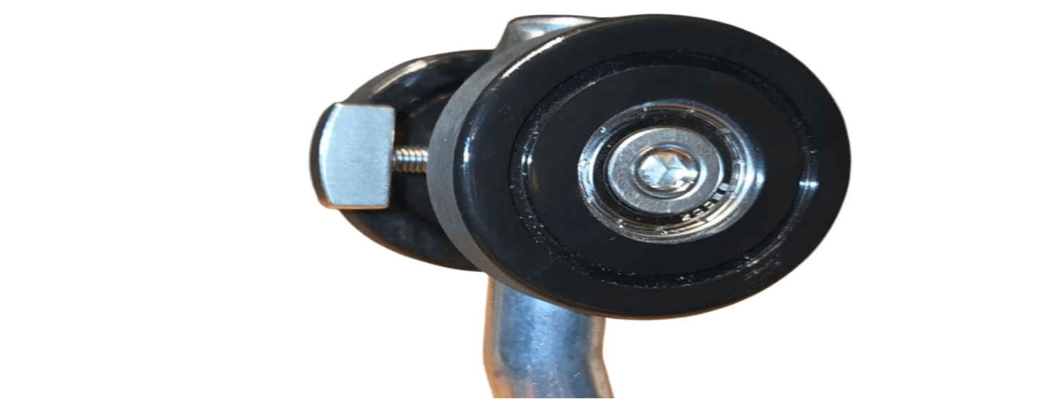 Zwarte metalen handgreep met oranje grip en twee grote wielen, geschikt voor zware kasten of industriële kasten. Geschikt voor gebruik in keukens, garages of opslagruimtes.