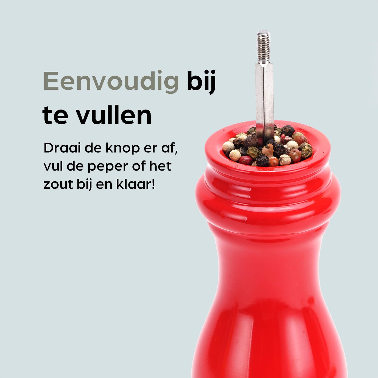 Rode houten pepermolen en zoutmolen van Hermanos, met glanzende lak en goudkleurige doppen, geplaatst op een maroon standaard met extra doppen voor keukengebruik.