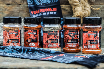 Een glazen pot met een zwarte dop, gevuld met oranje-rode BBQ-rub, van Van Beekum Specerijen. Het etiket toont een rood varken en de tekst 'Toet Toet Oink Oink' voor pulled pork rub.