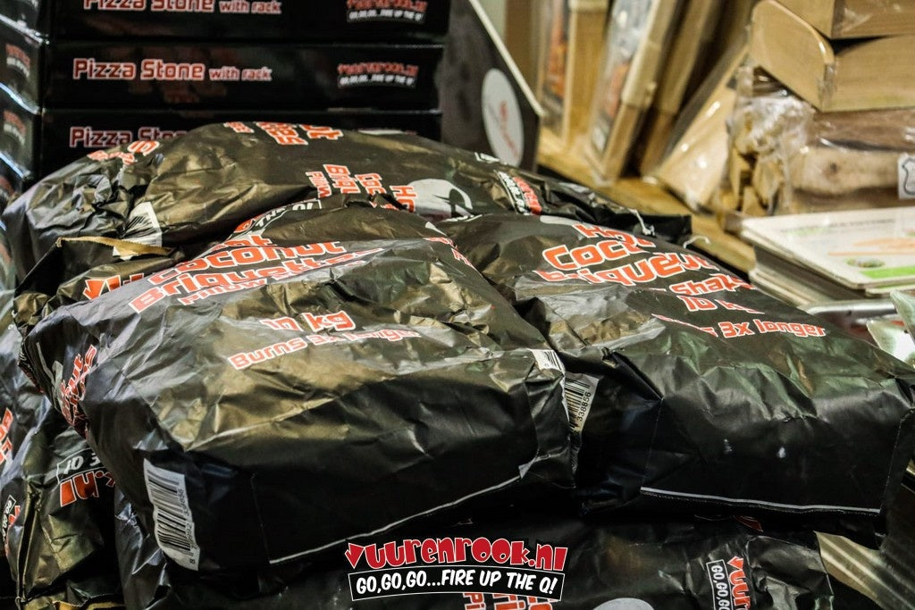 Hot Coconut Briquettes in een zwarte verpakking met rood-wit lettertype, pillowvormig en 10 kg, geschikt voor grillen en barbecueën. Brandt 3x langer dan gewone houtskool.