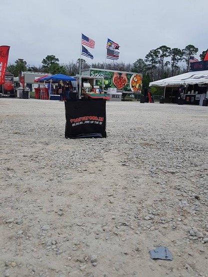 Zwarte, glanzende draagtas met rode en witte tekst 'Vuurenrook.nl' en slogan 'GO,GO,GO...FIRE UP THE Q!'. Geschikt voor barbecue- of grill-evenementen, met sterk contrast en duidelijke branding.